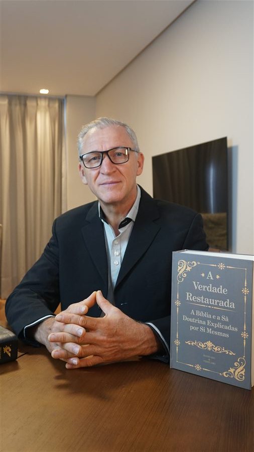 Daniel Ferreira da Rosa holding the book The Restored Truth